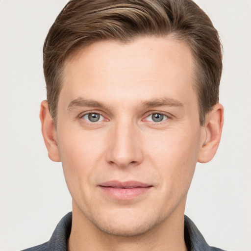 Joyful white young-adult male with short  brown hair and grey eyes