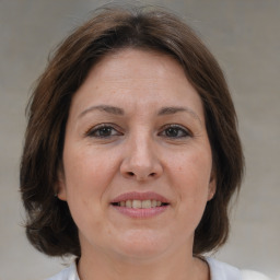 Joyful white adult female with medium  brown hair and brown eyes