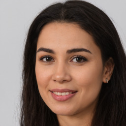 Joyful latino young-adult female with long  brown hair and brown eyes