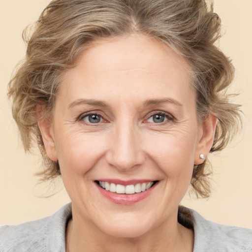 Joyful white adult female with medium  brown hair and blue eyes