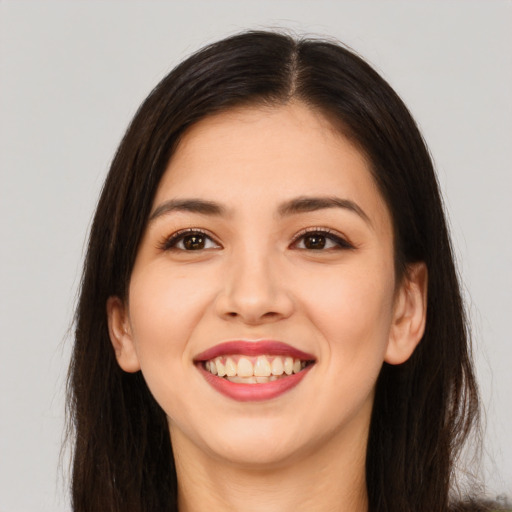 Joyful asian young-adult female with long  brown hair and brown eyes