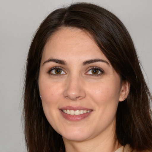 Joyful white young-adult female with long  brown hair and brown eyes