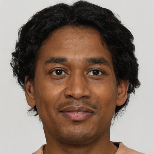 Joyful black adult male with short  brown hair and brown eyes