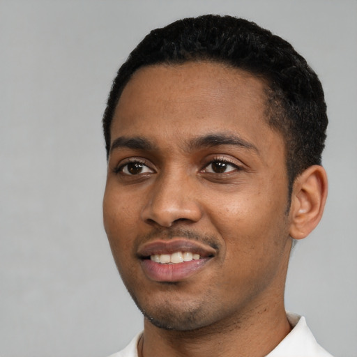 Joyful black young-adult male with short  black hair and brown eyes