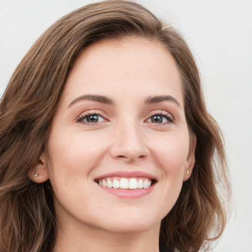 Joyful white young-adult female with long  brown hair and green eyes