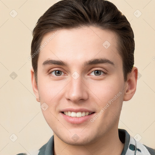 Joyful white young-adult male with short  brown hair and grey eyes