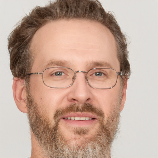 Joyful white adult male with short  brown hair and green eyes