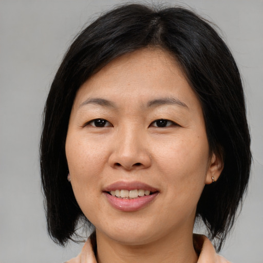 Joyful asian adult female with medium  brown hair and brown eyes