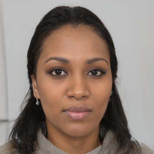 Joyful black young-adult female with long  brown hair and brown eyes