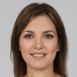 Joyful white young-adult female with long  brown hair and grey eyes