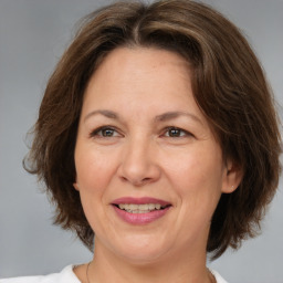 Joyful white adult female with medium  brown hair and brown eyes