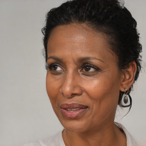 Joyful black adult female with short  black hair and brown eyes