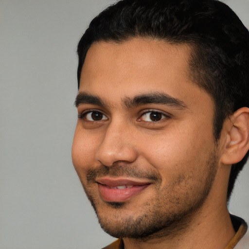Joyful latino young-adult male with short  black hair and brown eyes