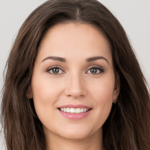 Joyful white young-adult female with long  brown hair and brown eyes