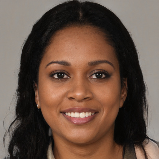 Joyful black young-adult female with long  brown hair and brown eyes