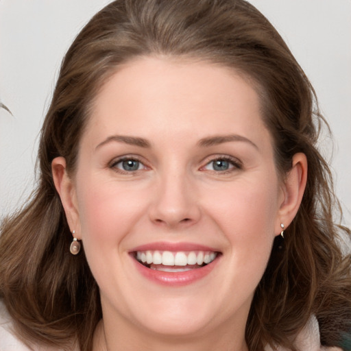 Joyful white young-adult female with medium  brown hair and blue eyes