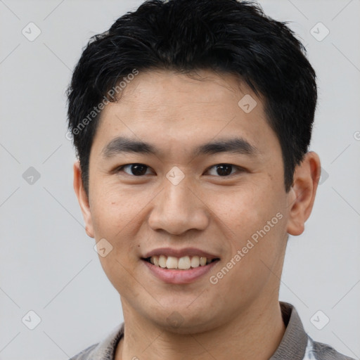 Joyful asian young-adult male with short  black hair and brown eyes