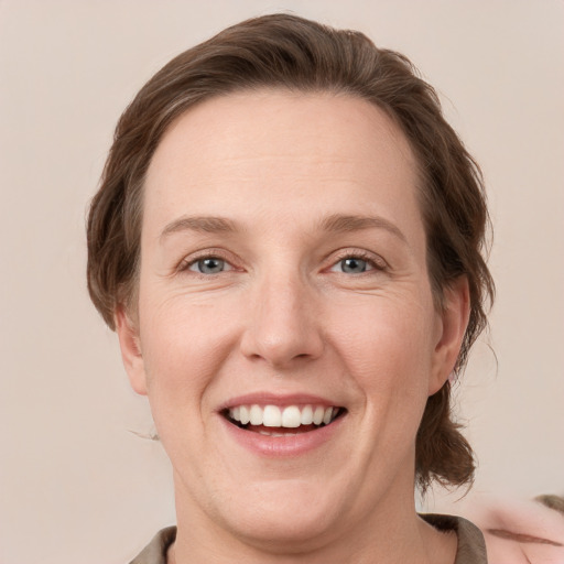 Joyful white adult female with medium  brown hair and grey eyes