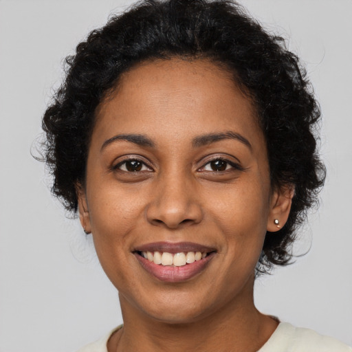Joyful black young-adult female with short  brown hair and brown eyes