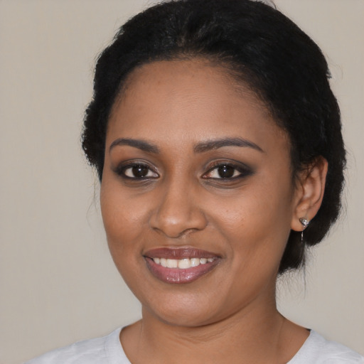 Joyful black young-adult female with short  black hair and brown eyes