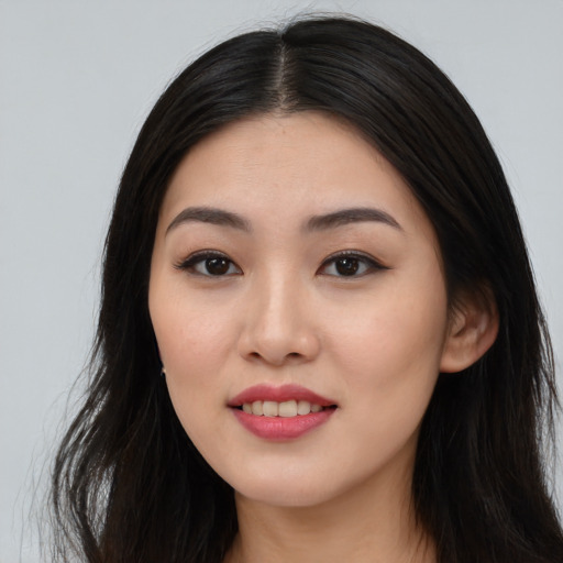 Joyful asian young-adult female with long  black hair and brown eyes