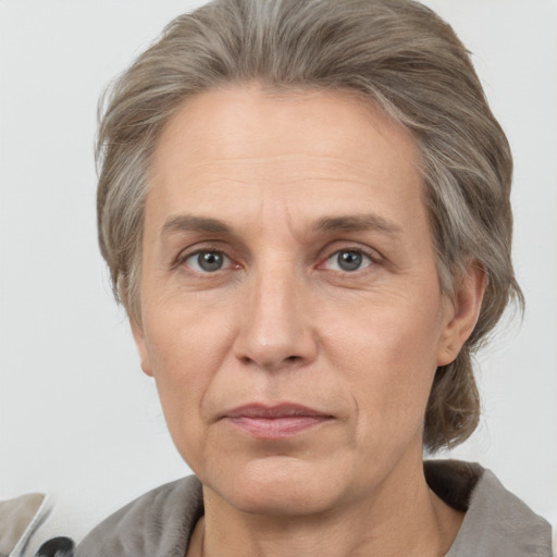 Joyful white adult female with medium  brown hair and grey eyes