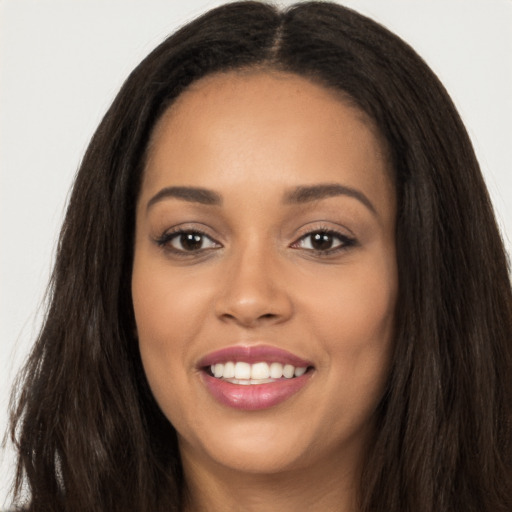 Joyful latino young-adult female with long  brown hair and brown eyes