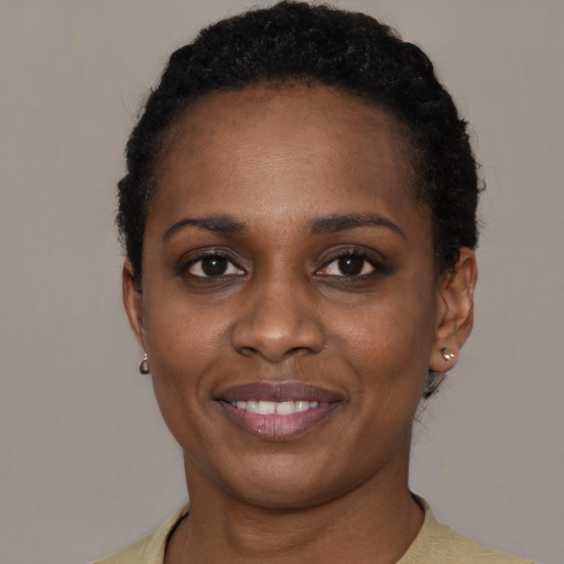 Joyful black young-adult female with short  black hair and brown eyes