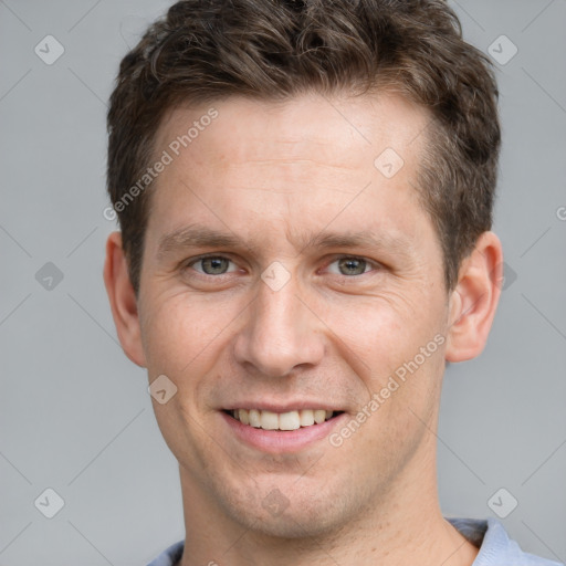 Joyful white young-adult male with short  brown hair and grey eyes