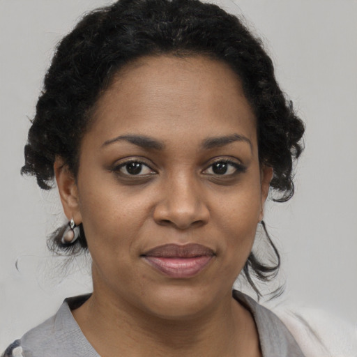 Joyful black young-adult female with short  brown hair and brown eyes