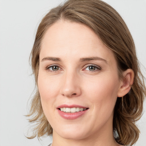 Joyful white young-adult female with medium  brown hair and green eyes