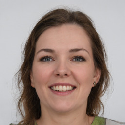 Joyful white young-adult female with medium  brown hair and grey eyes