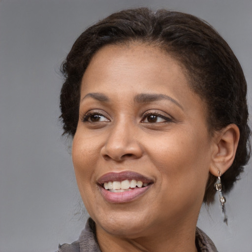 Joyful black adult female with medium  brown hair and brown eyes