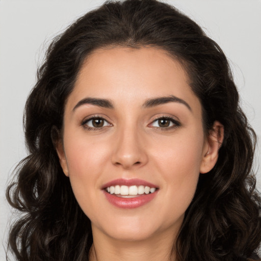 Joyful white young-adult female with long  brown hair and brown eyes