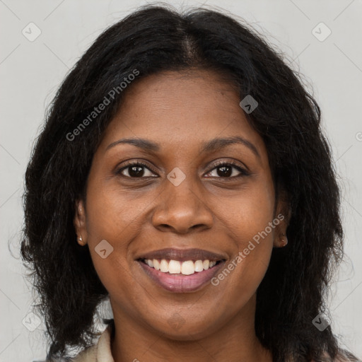 Joyful black adult female with long  brown hair and brown eyes