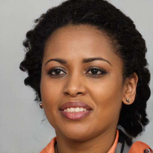 Joyful black young-adult female with long  black hair and brown eyes