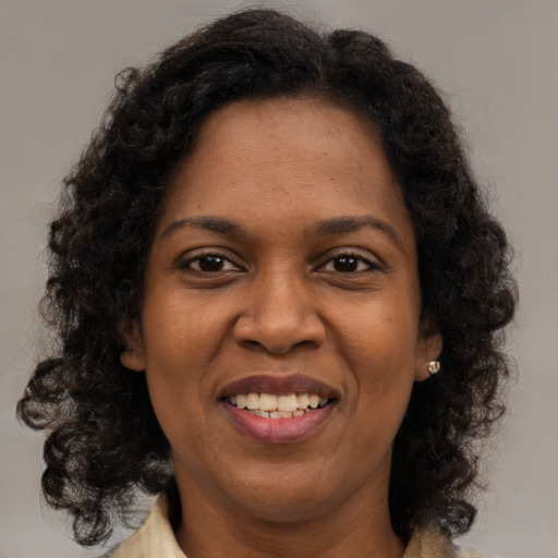 Joyful black young-adult female with medium  brown hair and brown eyes