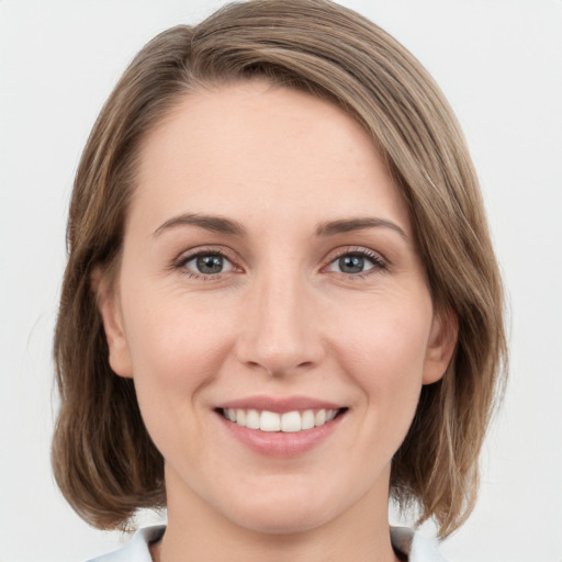 Joyful white young-adult female with medium  brown hair and green eyes