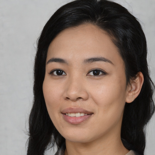 Joyful asian young-adult female with long  black hair and brown eyes