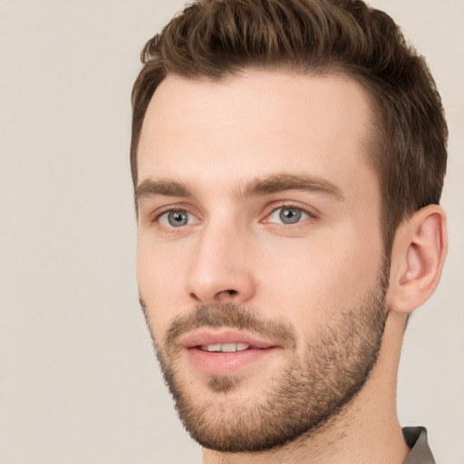 Joyful white young-adult male with short  brown hair and grey eyes