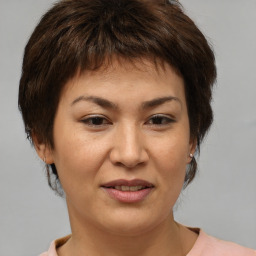 Joyful asian adult female with medium  brown hair and brown eyes