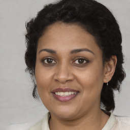 Joyful black adult female with medium  brown hair and brown eyes