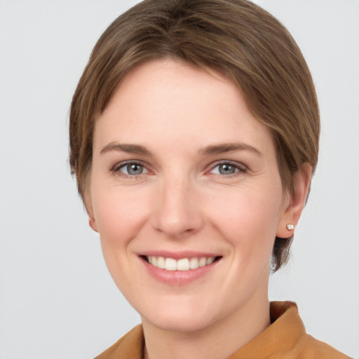 Joyful white young-adult female with short  brown hair and grey eyes