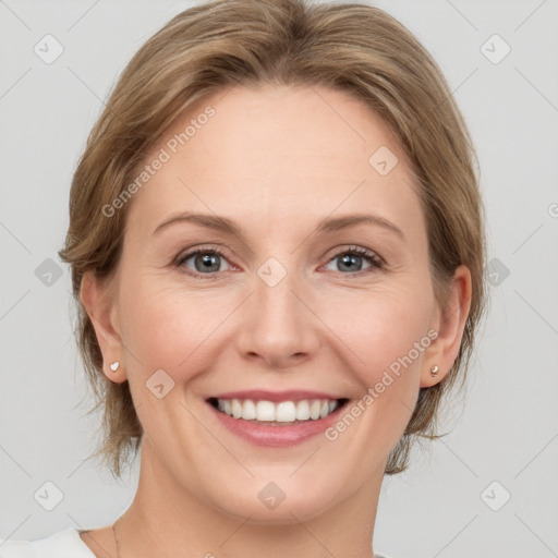 Joyful white adult female with medium  brown hair and grey eyes