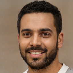 Joyful latino young-adult male with short  black hair and brown eyes