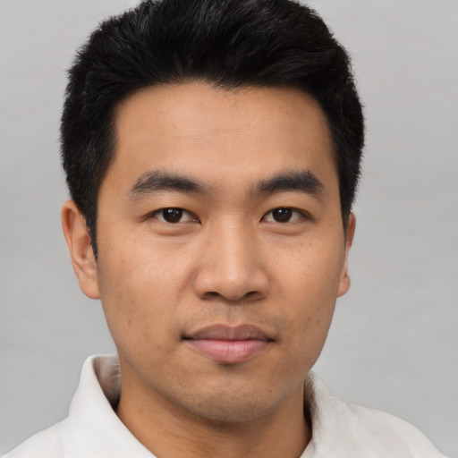 Joyful asian young-adult male with short  black hair and brown eyes