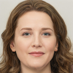 Joyful white young-adult female with long  brown hair and green eyes