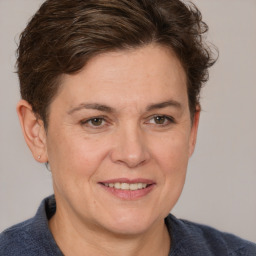 Joyful white adult female with medium  brown hair and grey eyes