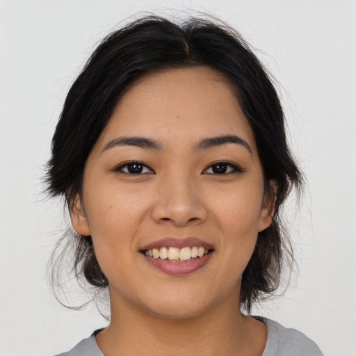 Joyful asian young-adult female with medium  black hair and brown eyes
