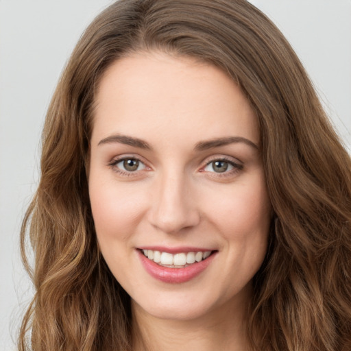 Joyful white young-adult female with long  brown hair and green eyes